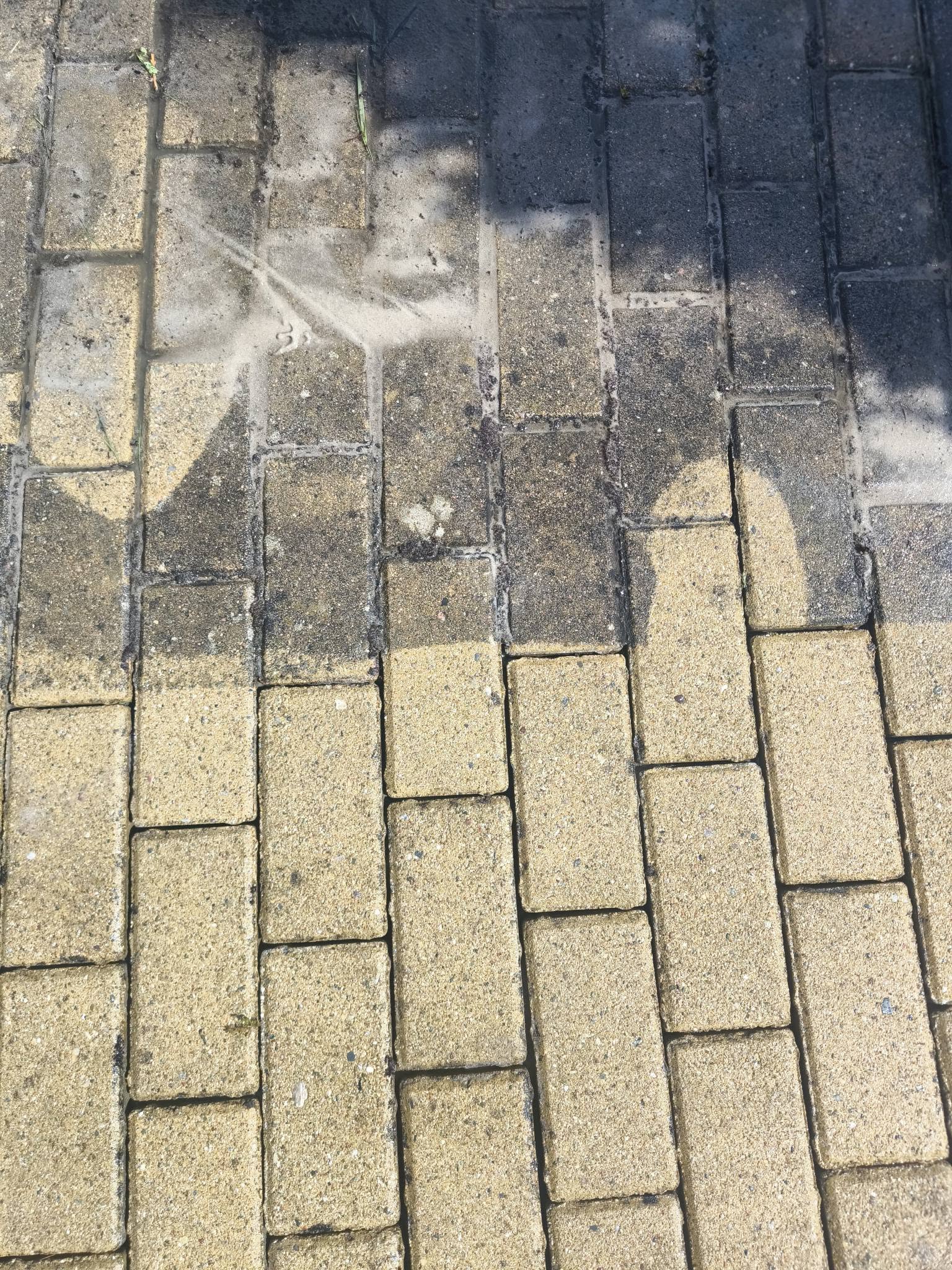 Kostka brukowa w połowie oczyszczona z zabrudzeń